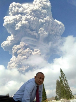 Dedi Nelson, dengan latar erupsi Gunung Sinabung, Senin pagi. (Foto/Dedi)