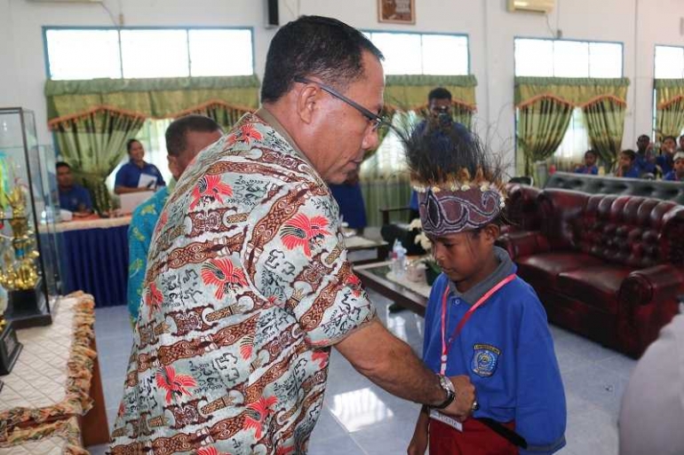 Plt. Sekda Raja Ampat menyematkan tanda peserta lomba cerita rakyat/foto: Romeo Omkarsba