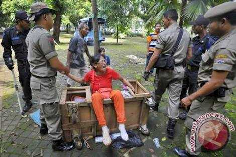 Kadang Satpol PP dihadapkan pada situasi memindahkan orang yang dia sendiri mengenalnya dengan baik. Ini soal aturan, yang harus dipatuhi semua pihak. (foto: Antaranews)