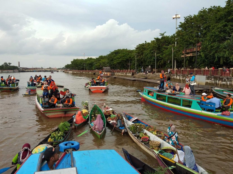 Pedagang Pasar Terapung Berinteraksi Dengan WIsatawan (dokpri)