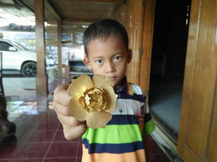 Seorang Anak Menunjukkan Temuan Benda Purbakala berupa Emas berbentuk Bunga di Grobogan, Jawa Tengah, Diduga berkaitan dengan Kerajaan Medang. (Sumber: kebumenekspres.com)