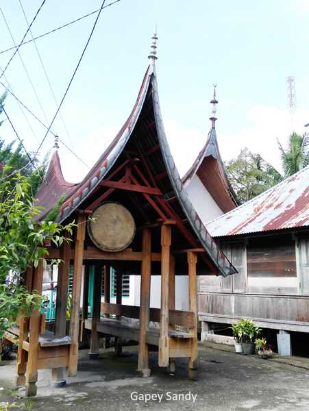 Di halaman depan ada bangunan berbentuk rumah adat Minangkabau tempat meletakkan bedug. (Foto: Gapey Sandy)