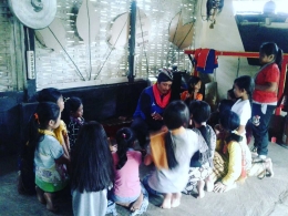 Foto : Ade, Seniman Pujon Kidul saat mengenalkan alat musik tradisional pada anak-anak disana