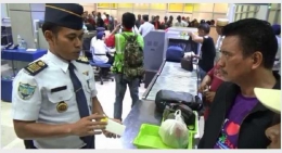 Deskripsi : Petugas Bandara Udara Sultan Hasanuddin Makassar menjelaskan tentang power bank I Sumber Foto : iNews/Wahyu Ruslan