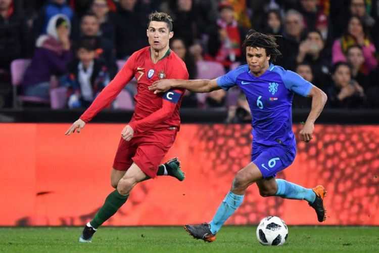 Cristiano Ronaldo dan Nathan Ake berebut bola pada pertandingan uji coba antara Portugal dan Belanda di Geneva, Senin (26/3/2018). 