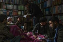 Warga Afghanistan sedang membaca puisi di sebuah toko di Kabul. Fenomena peningkatan minat baca buku bisa menjadi cara terbaik dalam situasi konflik perang sipil saat ini. (The New York Times/Mauricio Lima)