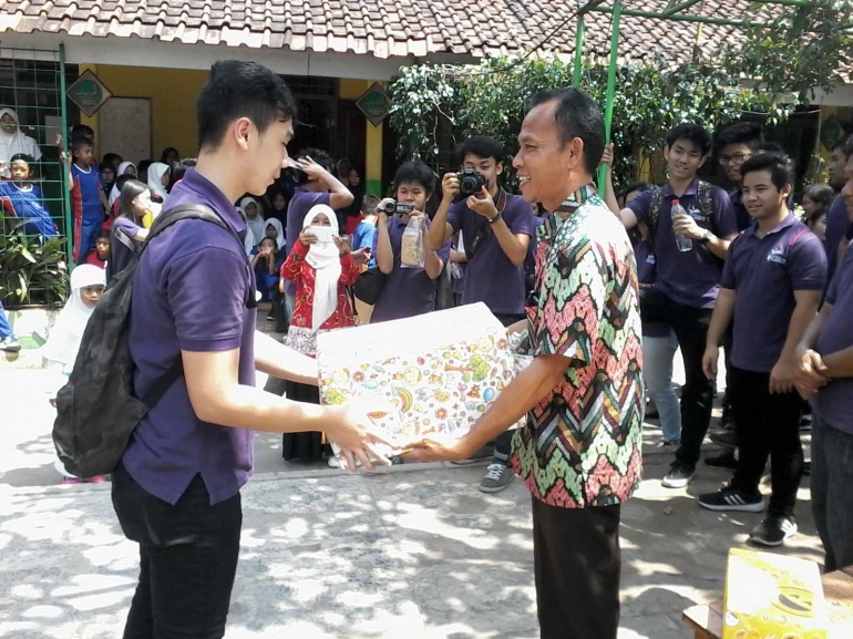 Pemberian cenderamata kepada kepala sekolah SDN Sukaresmi 06 Cikarang Selatan Bekasi (Dokpri)