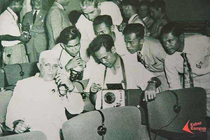 Wartawan peliput KAA 1955 sibuk melakukan wawancara. (Foto: Repro Frino Bariarcianur)