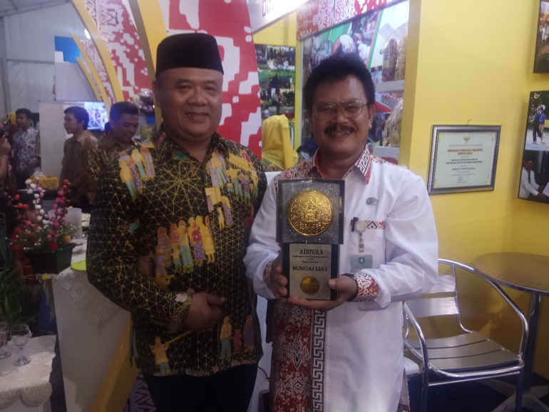 Sekda Bangka Akhmad Mkhsin dan Asisten perekonmian dan pembangunan Setda Provinsi Bangka Belitung Budiman Ginting memagang piala Adipura yang ke 9 kali untuk kota Sungailiat (foto Rustian)