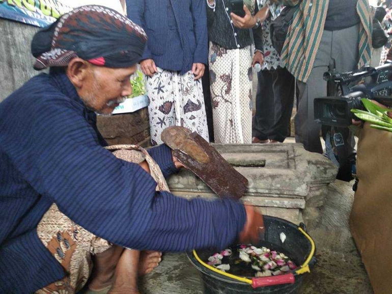 Pencucian cangkul oleh sesepuh setempat, Bapak Sudarno