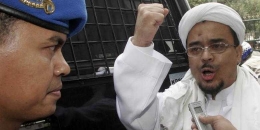 Rizieq Shihab mengepalkan tangan usai divonis 1,5 tahun penjara di tahun 2013 lalu karena terbukti menyerang massa Aliansi Kebangsaan untuk Kebebasan Beragama dan Berkeyakinan di Monas. Foto: TRIBUNNEWS.com 