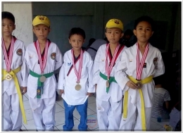 Zaky (tengah) berkalung medali emas pasca bertanding kejuaraan taekwondo di Makassar (06/05/18).