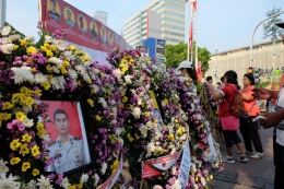 Beberapa warga mengamati 6 foto anggota kepolisian di kawasan Sarinah, Jakarta Pusat, Minggu 13 Mei 2018. Keenam polisi tersebut menjadi korban tewas saat kerusuhan di Mako Brimob yang dilakukan para napi teroris beberapa waktu lalu. (dokpri)