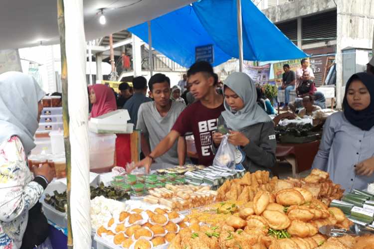 Pedagang gorengan di pasar takjil Bendungan Hilir tengah melayani pembeli, Kamis (17/5/2018) (KOMPAS.com/NURSITA SARI)