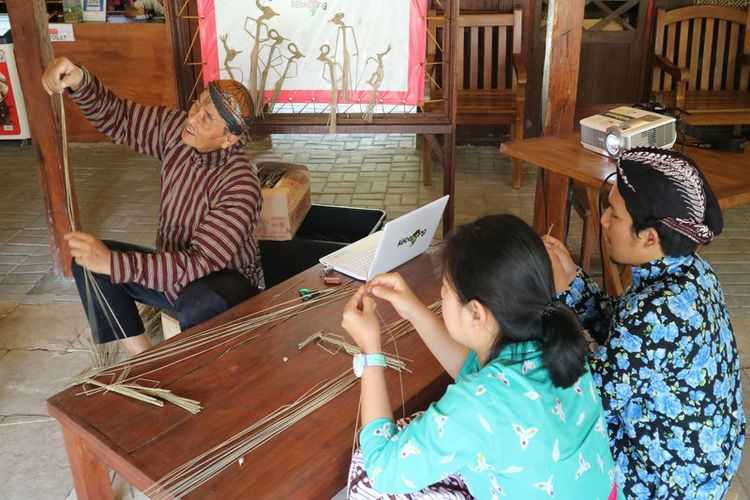 Wisatawan sedang belajar membuat wayang suket di Omah Kecebong. 