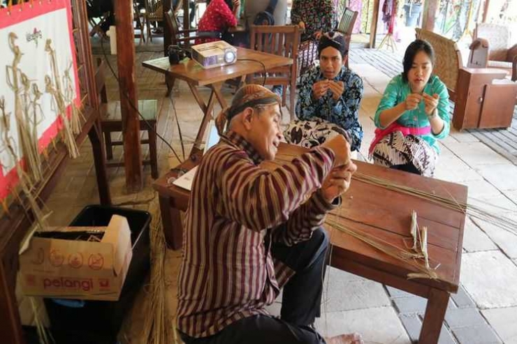 Wisatawan belajar membuat wayang suket di Omah Kecebong. 