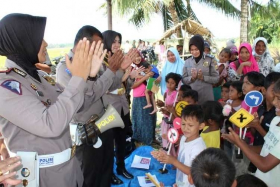 Polisi wanita bernyanyi bersama anak pengungsi korban banjir di lokasi pengungsian Desa Mampree, Kecamatan Syamtalira Aron, Kabupaten Aceh Utara, Kamis (14/12/2017).