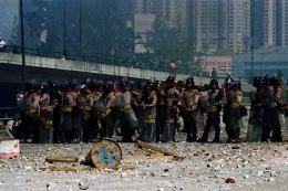 Anggota polisi berjaga setelah kerusuhan meletup di Simpang Grogol, Jakarta, 13 Mei 1998.