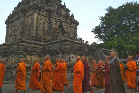 Umat dan tokoh Buddha melakukan ritual pradaksian sebelum menyemayamkan air berkah di dalam Candi Mendut Magelan, Jawa Tengah, Senin (28/5/2018). Ritual ini merupakan bagian kegiatan memperingati Tri Suci Waisak 2572BE/2018.(KOMPAS.com/IKA FITRIANA)