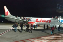 Penumpang Lion Air keluar dari dalam pesawat melalui pintu darurat, Senin (28/5/2018) malam. Kejadian berawal ketika seorang penumpang berinisial F, asal Wamena Papua bercanda terkait adanya bom. (Sumber: kompas.com/Handout)
