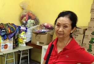 Maria Francisca dengan latar belakang sejumlah barang sumbangan yang akan dijual di pasar murah. (Foto: BDHS)