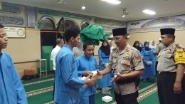 Kapolsek Palmerah Kompol Aryono didampingi Bhabinkamtibmas Slipi Aiptu Asep Permana sedang berikan santunan yatim