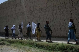 Pasukan Taliban di Afghanistan berjalan untuk merayakan gencatan senjata pada hari kedua Idul Fitri di pinggiran Jalalabad pada Sabtu (16/6/2018). (AFP/Noorullah Shirzada)