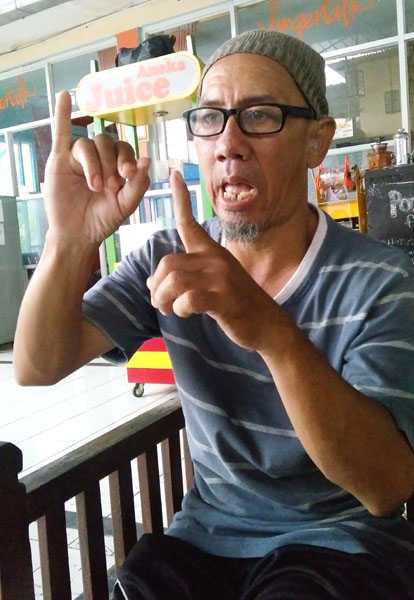 Agus Solihin berkomunikasi dengan bahasa isyarat. (Foto: Gapey Sandy)