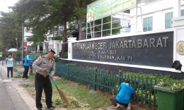 Kanit Patroli Polsek Palmerah Iptu Sakiyo melakukan kerja bakti bersih-bersih di halaman Pengadilan Negeri Jakarta Barat 