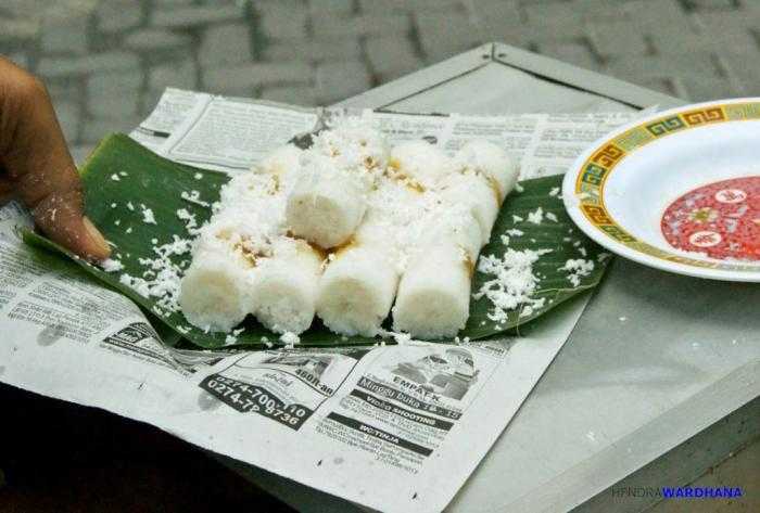 Setelah matang kue putu diberi taburan kelapa parut dan dibungkus dengan daun pisang serta kertas koran.