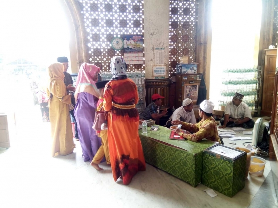 Para peziarah membeli air mineral sumber dari masjid. - Dokumen Pribadi.