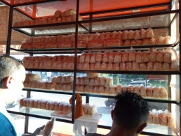 Display roti selai Samahani disebuah warung kopi di pasar Samahani. Seorang penjual bersama karyawannya sedang melayani para pembeli roti selai di kedai mereka. Gambar ini didokumentasikan pada hari Rabu, 27 Juni 2018 bertepatan dengan peringatan Hari UMKM Internasional di Aceh. (foto: koleksi pribadi) 