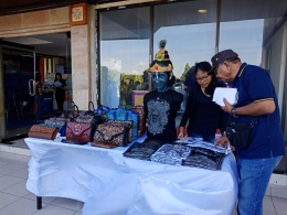 kerajinan berupa tas dan kaos khas Bali dipamerkan dan diperjualbelikan di depan GOR Lila Bhuana, ketika turnamen tenis meja nasional Bali Open 2018 berlangsung