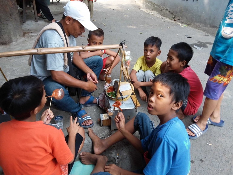 Pedagang gulali dikelilingi anak kecil. Foto | Dokpri