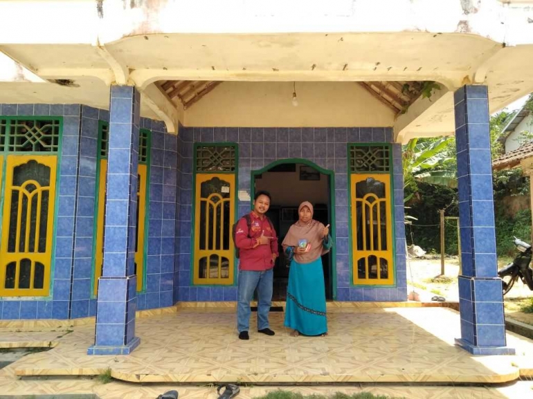 Pendamping Sosial dan Siti Munawaroh tengah berpose di Teras Rumah yang baru dibeli.