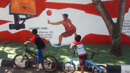 Petra dan Hafiz sedang memandangi mural legenda basket Indonesia, Liem Tjien Song (dok. pri).