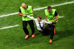 Anggota kelompok Pussy Riot, diaman oleh petugas keamanan pada pertandingan final Piala Dunia 2018 di Stadion Luzhniki di Moskwa, Rusia, Minggu (25/7/2018). (AFP/Mladen Antonov)