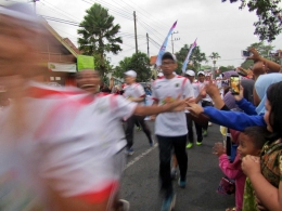 Lambaian tangan warga yang disambut oleh pelari. Satukan semangat dan energi untuk dukung penuh Asian Games 2018. - Dokumen Pribadi,