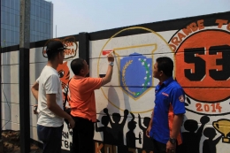 Camat Palmerah Zeri Ronazy melukis mural disaksikan Ketua Karang Taruna Jati Pulo Agus Setiawan dan Lurah Jati Pulo Ari Kurnia