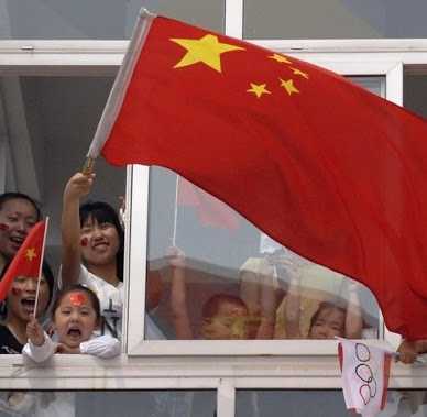 Warga Beijing kibarkan bendera nasional Tiongkok dari jendela apartemennya saat Olimpiade 2008. Foto: BBC.
