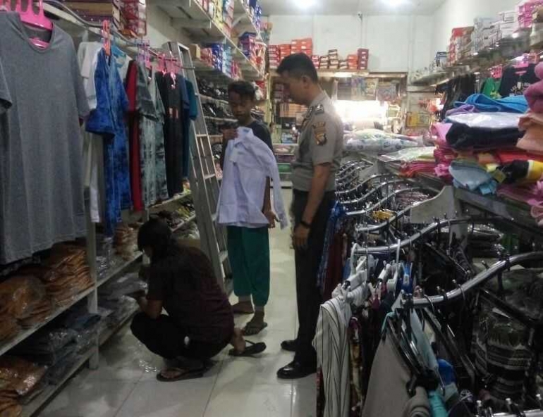 Dok: Bersama seorang polisi yang membantunya kembali bersekolah, Imam memilih seragam sekolah.