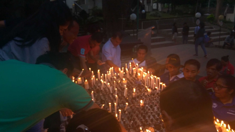 Membakar lilin di depan Gua Maria. Foto dokpri