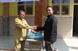 PENYERAHAN: Koordinator Desa Anota Hamsyah (kanan) menyerahkan wastafel kepada Kepala Yayasan PAUD Raudlatul Ulum, Bapak Mukromin (kiri) - Foto Oleh Humas KKN 116 UMM 2018