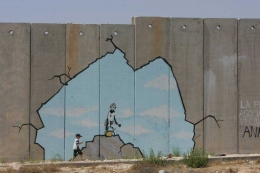 Mural Banksy yang melubangi tembok pemisah Israel dengan Palestina (ildolomite.it).