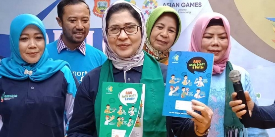 Menkes memberikan secara simbolis buku KIE kesehatan berupa buku tulis dan rapor kesehatan kepada SDN I Limboto, Gorontalo. . (Foto Ganendra)