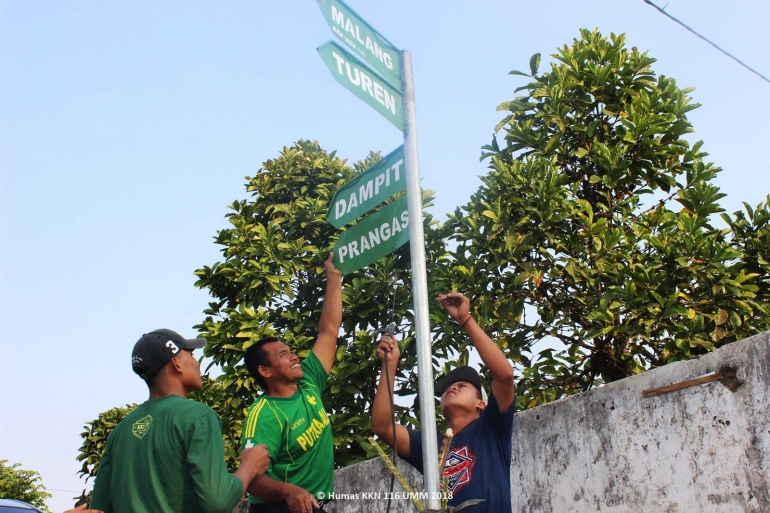 BERSINERGI, Mahasiswa KKN Berkerjasama dengan Warga Desa Majangtengah Membangun Petunjuk Arah Jalan - Foto Oleh Humas KKN 116 UMM