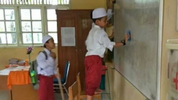 Murid Kelas VI SD Kartika XIV Banda Aceh sedang membersihkan ruang kelas belajar mereka dengan saling bekerjasama. (Dokumentasi Pribadi) 