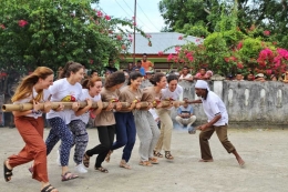 Beberapa anggota OCAS mencoba permainan tradisional bambu gila. Foto: Kemdikbud.