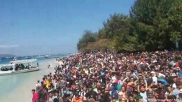 Kerumunan warga dan Wisman di salah satu pulau gili menunggu diangkut ke darat (Pulau Lombok) setelah ada rumor tsunami (Sumber: dw.dom)