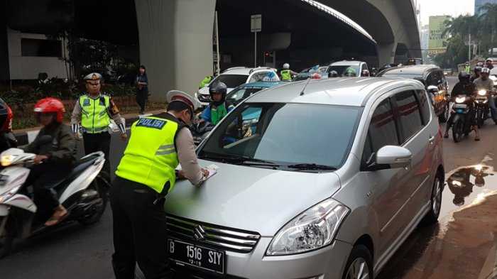 Pak Polantas sedang menilang pelanggar aturan lalu-lintas ganjil-genap di Pancoran, Jakarta (Foto: tribunjakarta.com)
